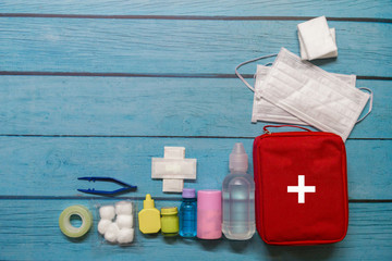 Top view first aid bag kid with medical supplies  on wood background.