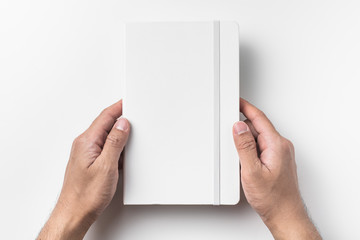 white notebook hold by man hand