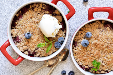 Berry crumble with nuts and ice cream on the kitchen table.