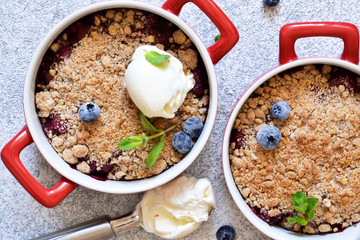 Berry crumble with nuts and ice cream on the kitchen table.