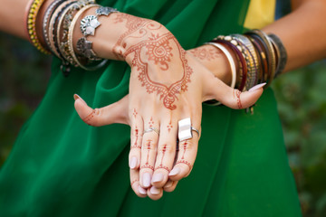 Beautiful woman in traditional Muslim Indian wedding green sari dress with henna tattoo jewelry and...