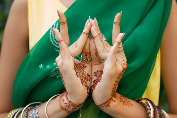 Beautiful woman in traditional Muslim Indian wedding green sari dress with henna tattoo jewelry...