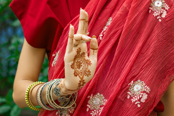 Beautiful woman in traditional Muslim Indian wedding pink red sari dress with henna tattoo jewelry...