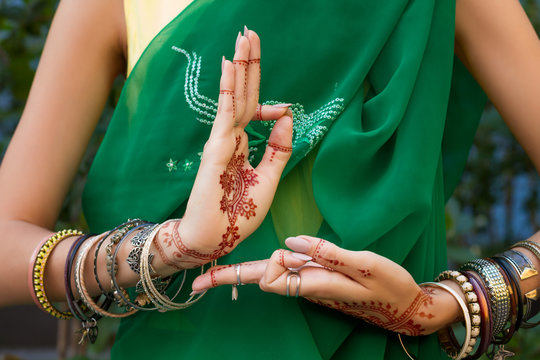 Beautiful woman in traditional Muslim Indian wedding green sari dress costume with henna tattoo jewelry and bracelets do hands nritta odissi Samyuta hastas dance Movement araala Concept background