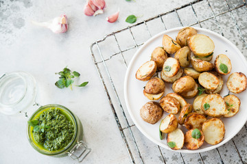 Baked potatoes in rustic style with green pesto sauce