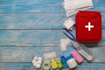 Top view first aid bag kid with medical supplies  on wood background.