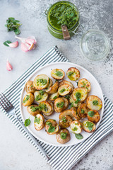 Baked potatoes in rustic style with green pesto sauce