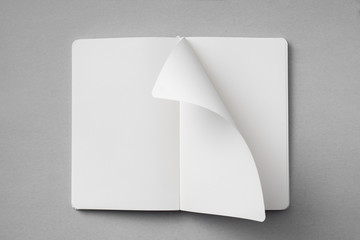 white notebook with turn page on grey background