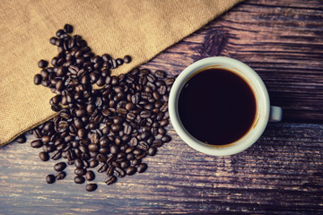 Hot coffee cup and beans on wooden background, Top view