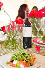 watermelon and rocket salad with table setting and wine