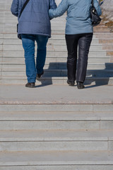 A man and a woman go up the stairs.