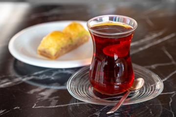 Turkish traditional tea (also called chai) with baklava on a stone table.