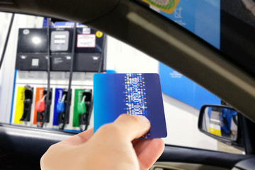 Man in car use credit card to make a payment for refueling car on gas station