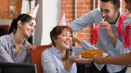 Excited diverse workers congratulate colleague with birthday in office