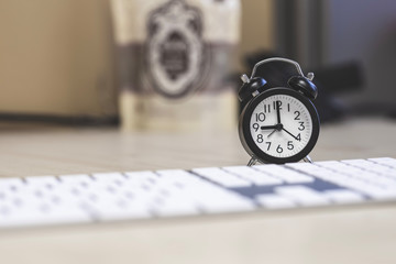 Closeup clock with keyboard on the desk office