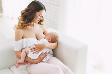 close up of mother breast feeding her newborn baby girl at home
