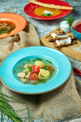 Red fish soup in a blue plate. Beautiful serving dishes. Restaurant menu