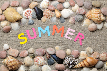 Inscription summer from paper of multi-colored letters and seashells and summer accessories on the sea sand. Summer. relaxation. vacation. top view