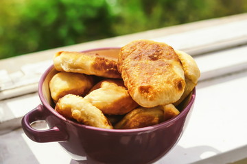 homemade pies in a plate on the windowsill.