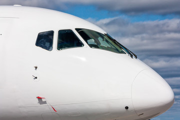 Close view of the cockpit of a white passenger plane outside
