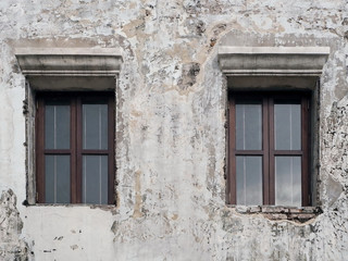 Fototapeta na wymiar Wooden Windows and Old White Concrete Wall of the Abandoned Building