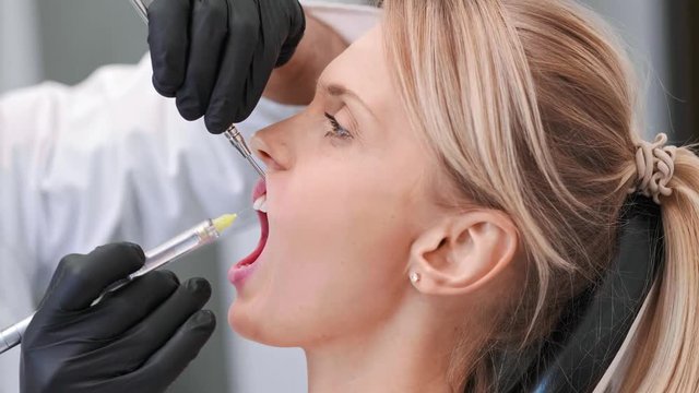 Part of dentist giving woman anesthesia in dentist's clinic