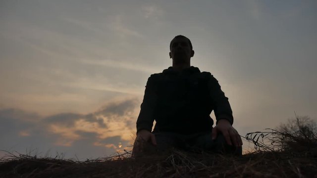 religion concept. silhouette of a male monk engaged in meditation lifestyle at sunset sunlight. Buddhist prayer at sunset healthy way of life nature