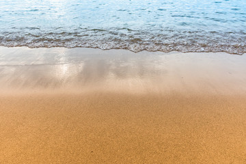 Soft wave of blue ocean on sandy beach.