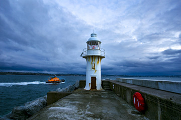 Harbour lighthouse and rescue boat at dawn