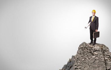 Young business person on the top of the rock with copy space
