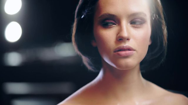 studio shoot of naked beautiful woman with makeup looking away
