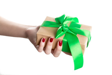 Hand woman holding gift box on isolated on white background. Gift wrap craft paper and green ribbon.