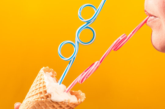 ice cream cone by to women lips with straws