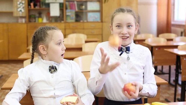 School lunch for children on the break between classes. Schoolgirl girls dine at school with apples, fruit and sandwiches with cheese and sausage