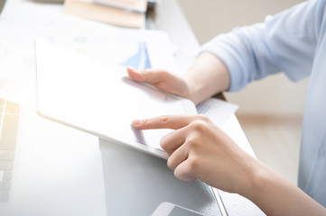 Business concept. Woman using tablet for project with digital device in office desk. Backlighting, sun glare effect, close up, side view, copy space