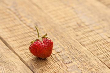 Ripe red strawberry on old wooden boards.