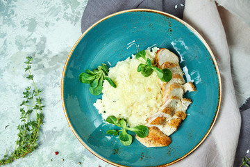 White rice with chicken breast. Rizotto. Gray light textured background. Beautiful serving of dishes. 