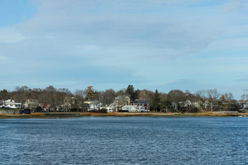Obraz premium Calm bay water with houses in background
