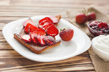 Morning breakfast. Toasts with strawberry and jam. Bread and confiture. Fresh hot toasts with cream. Delicious homemade dessert.