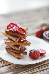 Morning breakfast. Toasts with strawberry and jam. Bread and confiture. Fresh hot toasts with cream. Delicious homemade dessert.