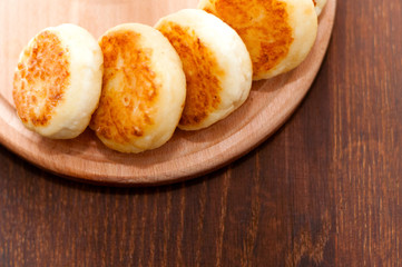 Cheese pancakes on a wooden board, horizontal format view from the top. For menu design and cafe advertising