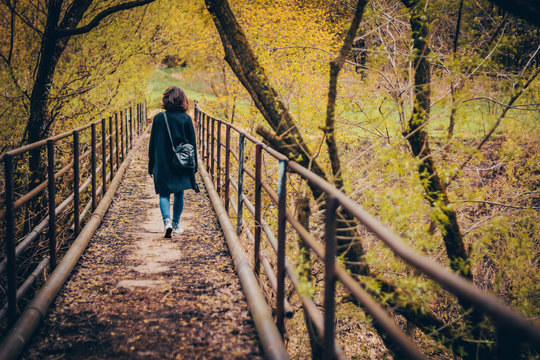 Woman walking in autumn park. Back view.