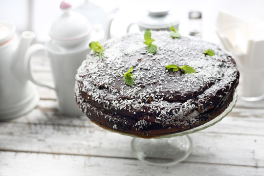 Chocolate cake with a chocolate coating and coconut chop decoration.