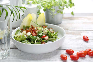 Salad with chicory, rapunzel, tomatoes, radish. A green, healthy vegetarian diet.