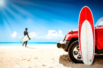Red summer car on beach and surfer. Free space for your decoration and summer sunny day. 
