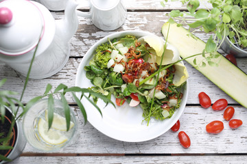 Salad with chicory, rapunzel, tomatoes, radish. A green, healthy vegetarian diet.
