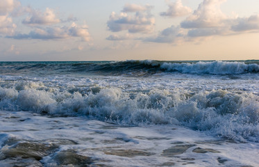 sea landscape is a pebbly beach with waves in white foam