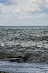 Fototapeta premium sea landscape is a pebbly beach with waves in white foam