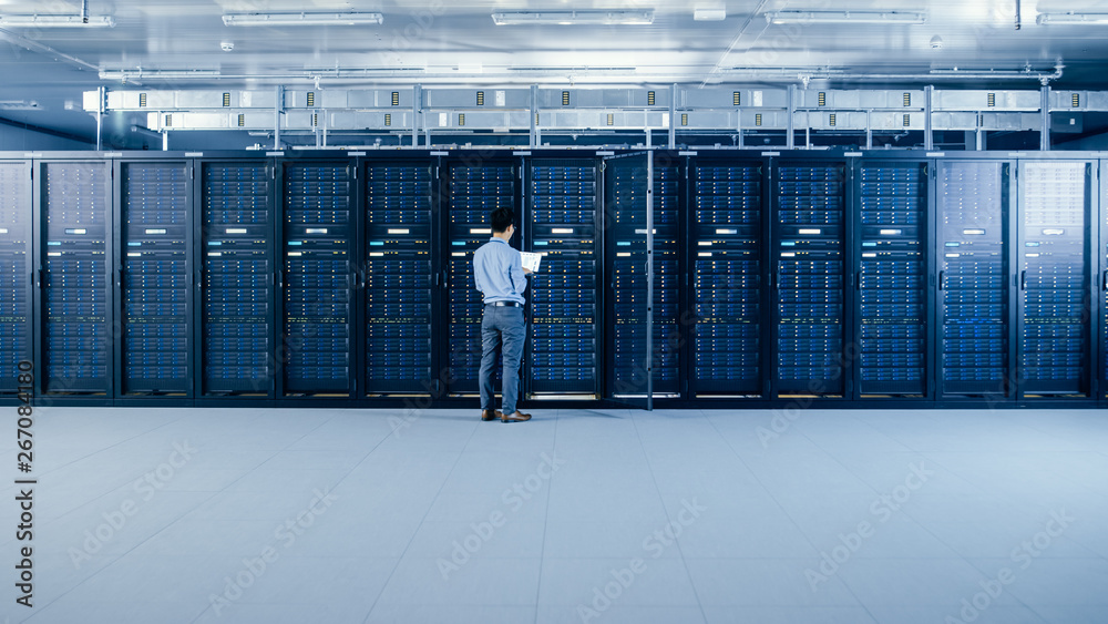 Aufkleber In the Modern Data Center: IT Engineer Standing Beside Open Server Rack Cabinets, Does Wireless Maintenance and Diagnostics Procedure with a Laptop.
