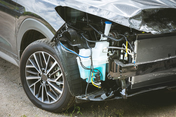 Broken and crashed modern grey car after an accident on street, damaged automobile after collision...